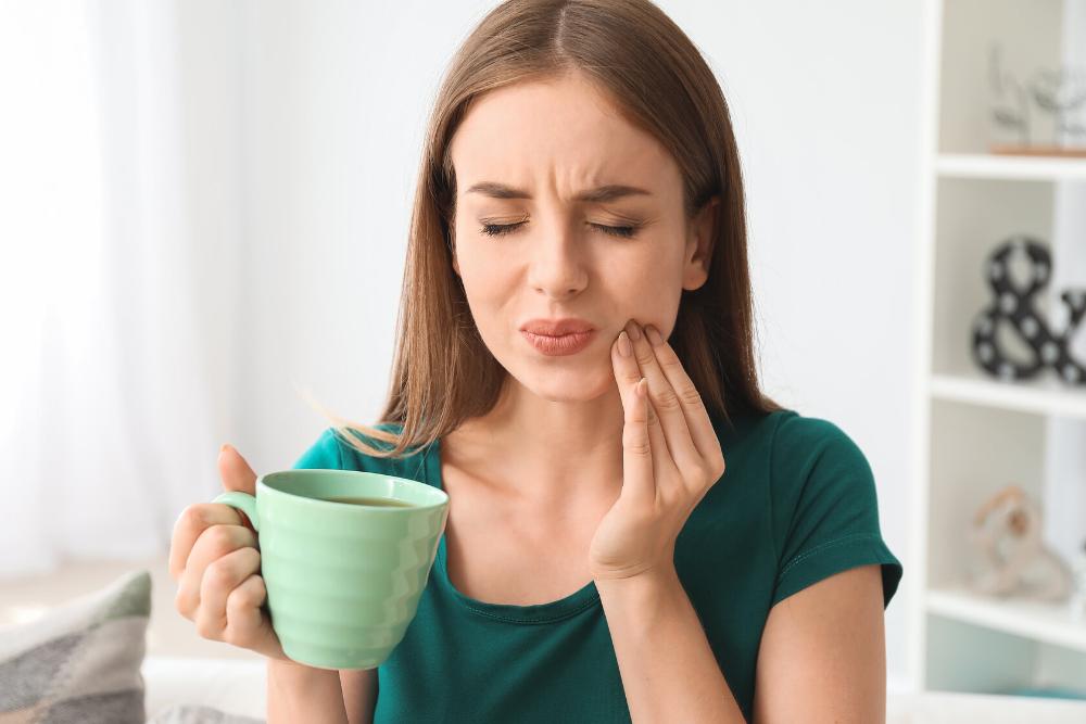 woman with tooth pain after drinking hot tea