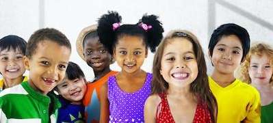 Group of smiling children standing together, showcasing bright and healthy teeth, symbolizing the im
