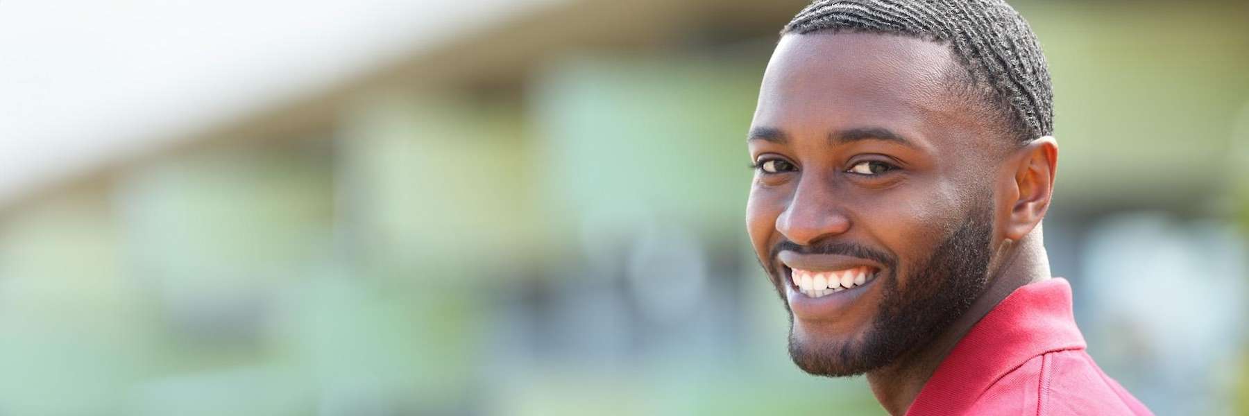 Smiling man outdoors showing healthy white teeth, representing the positive effects of good oral hyg