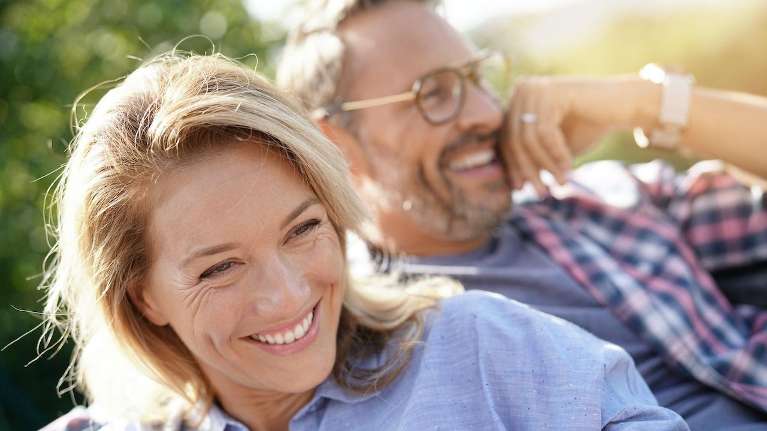 man and woman smiling while enjoying the sun in sandpoint