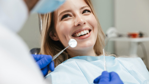 Relaxed woman smiling in dental chair during a comfortable dental procedure with dentist nearby