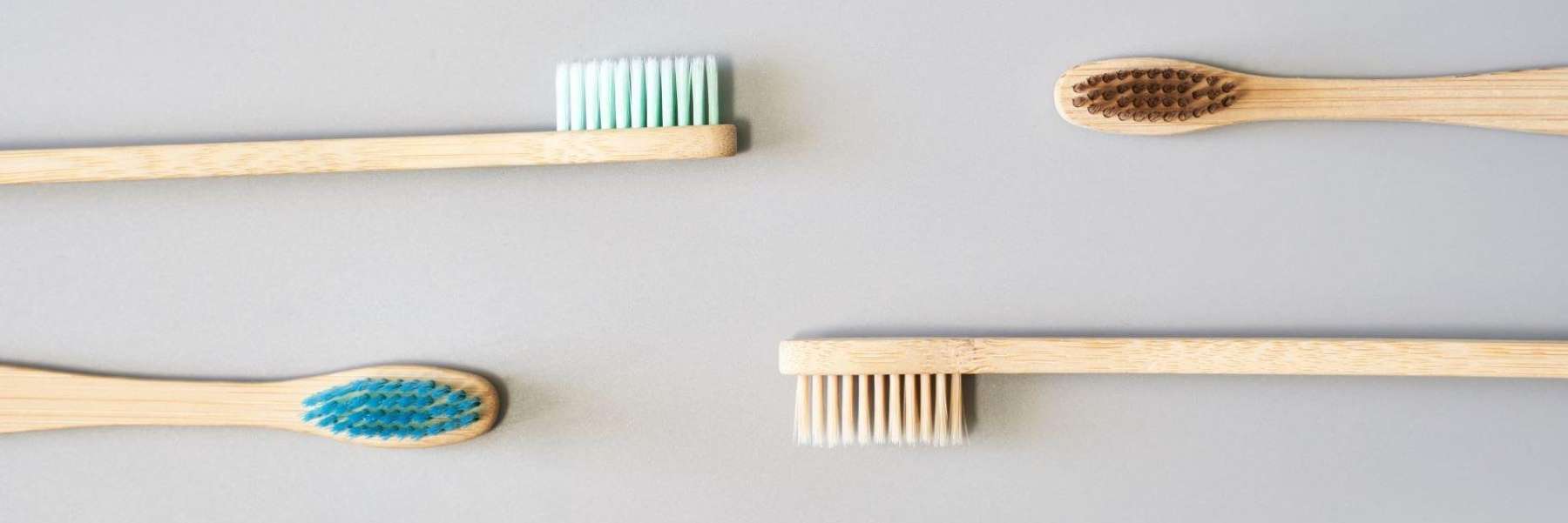Four wooden toothbrushes layed out, north idaho dental group