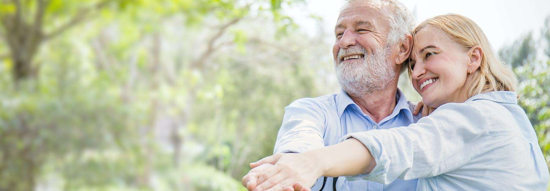 older couple smiling while dancing outside in park in sandpoint