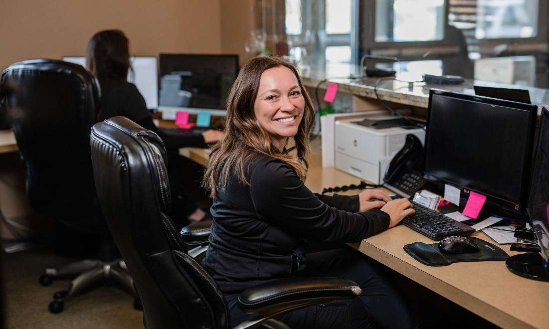 front desk team member smiling at computer